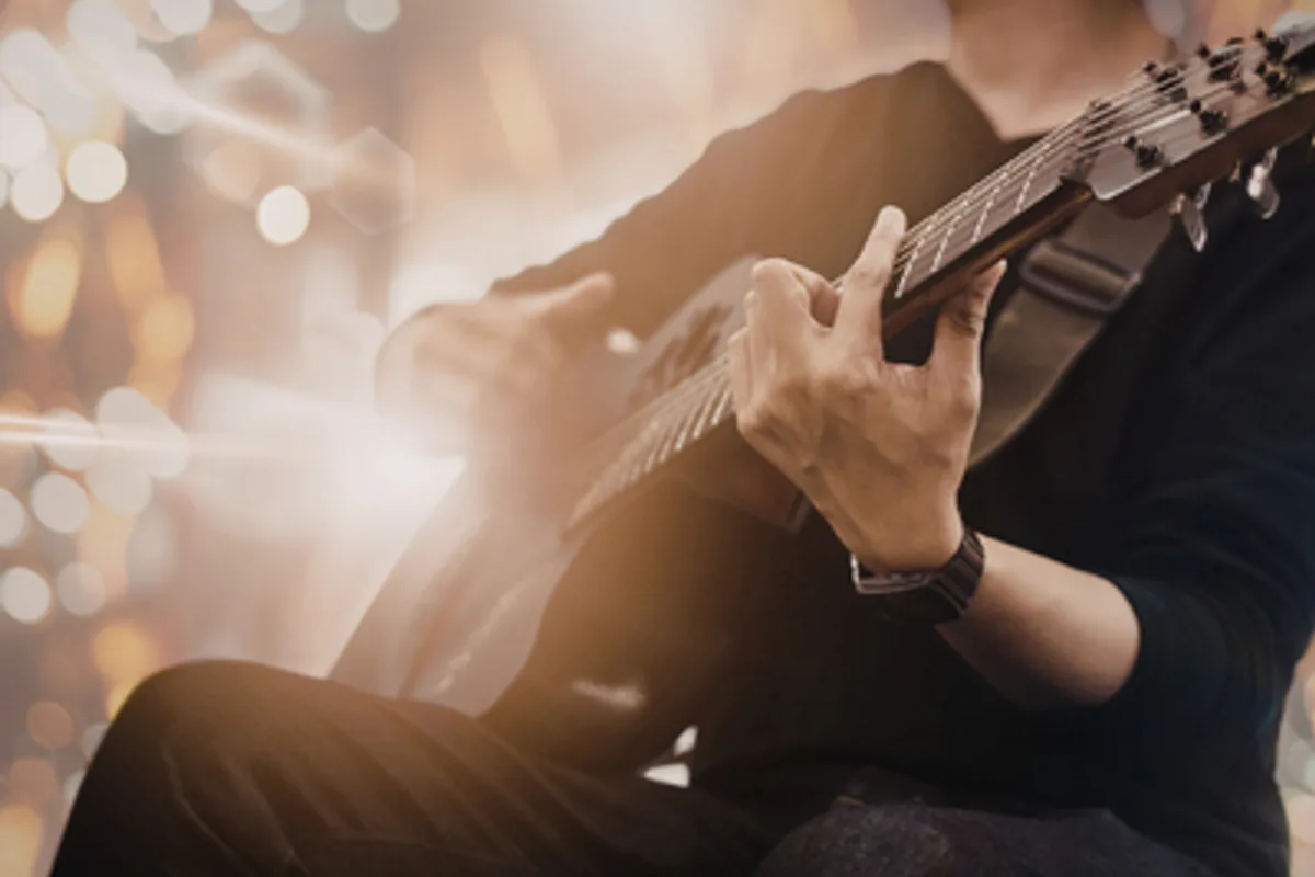 close up of a man playing guitar