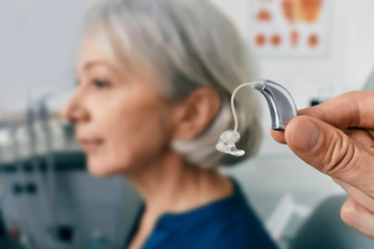 close up of a hearing aid in front of a woman