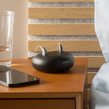 hearing aids sit on a bedside table