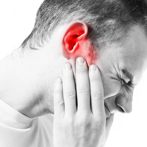 man holding his ear in extreme pain